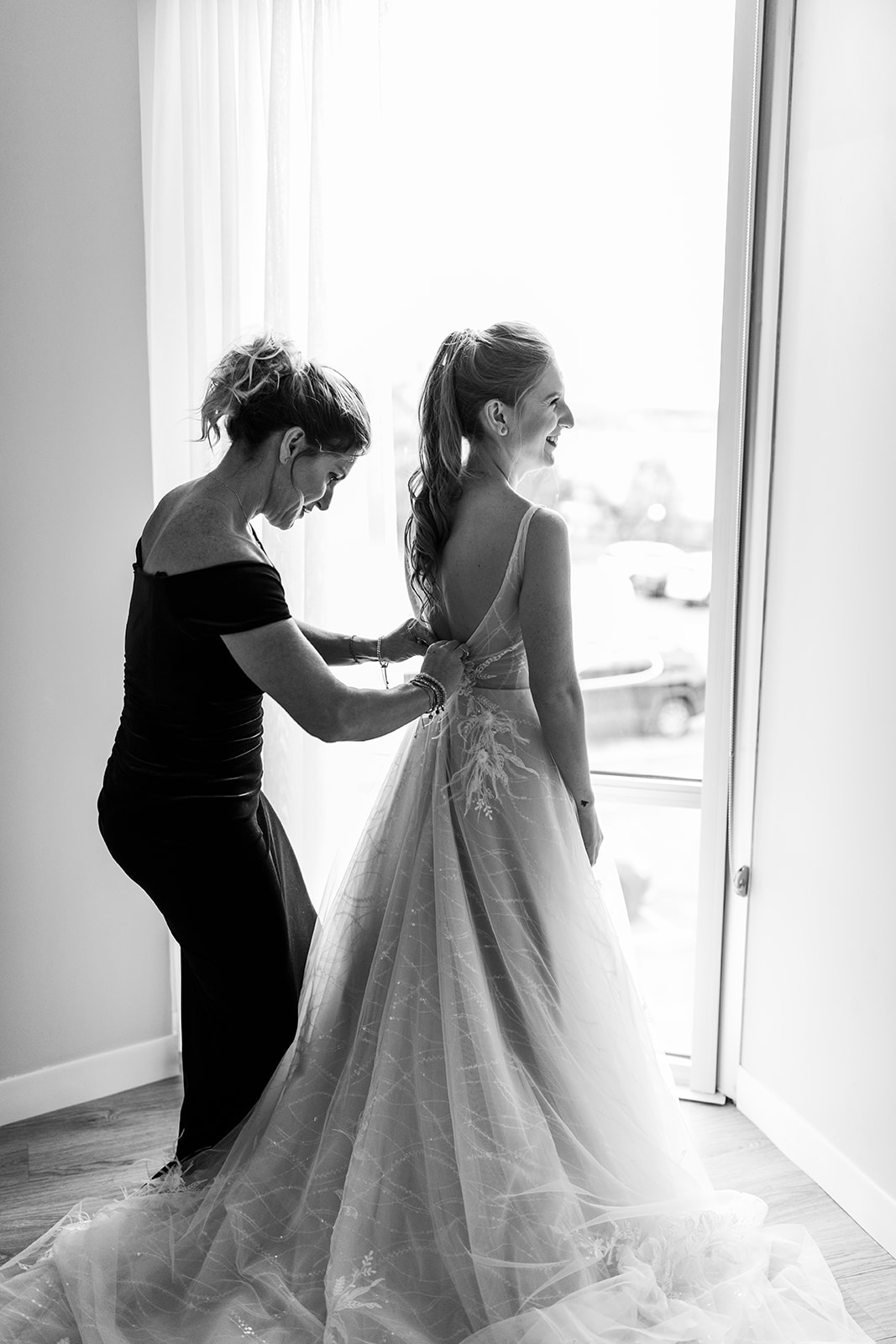 Mom helping bride put on wedding dress for Northern Michigan elopement