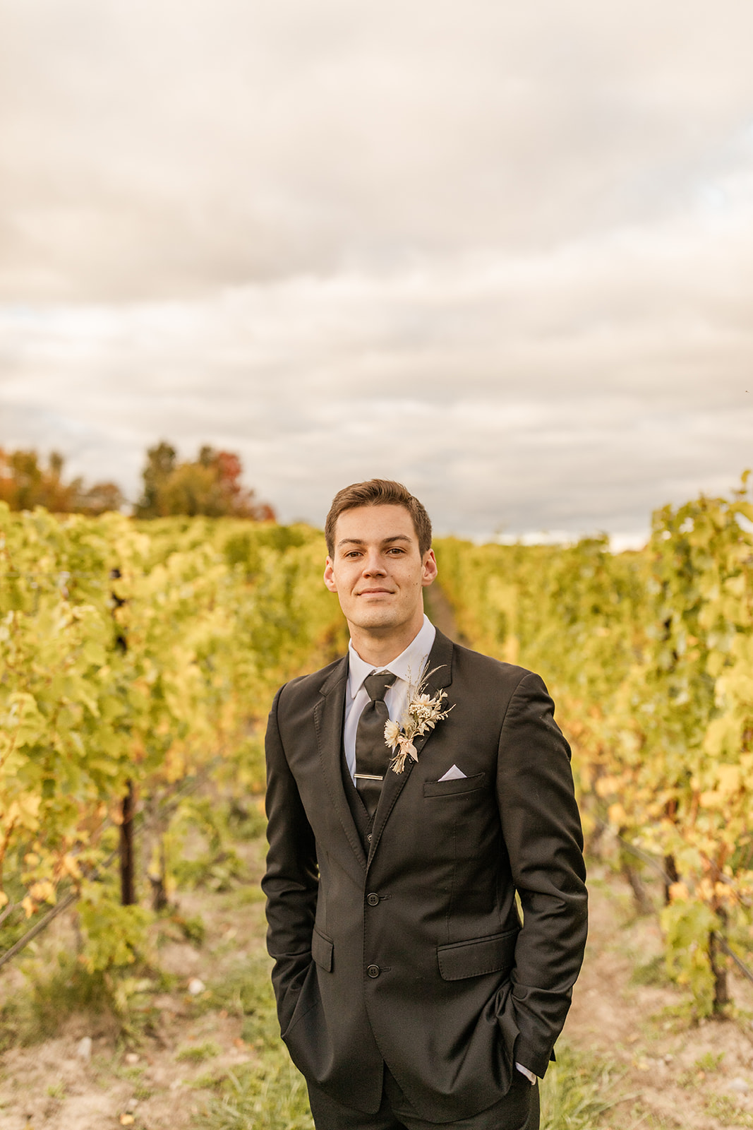 groom posing in vineyard in Michigan