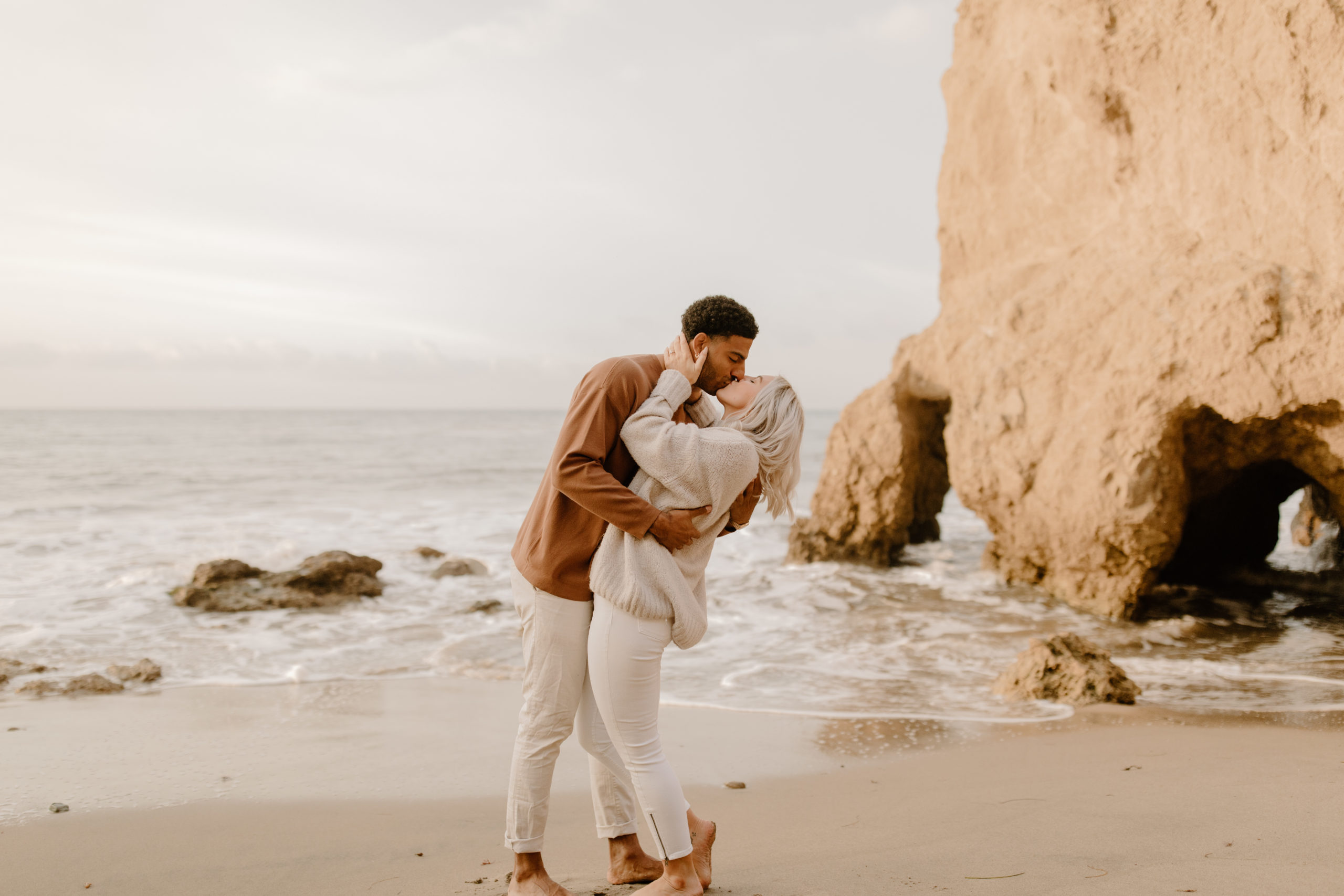 couple kissing at california beach engagement session