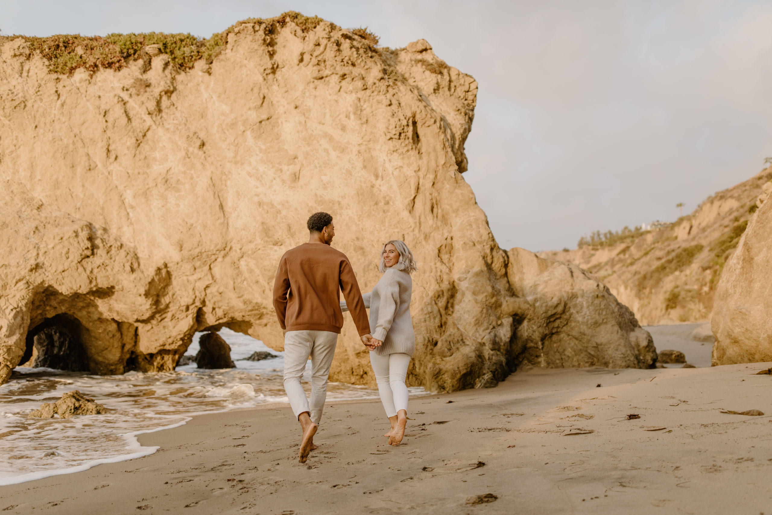 Malibu CA couple holding hands at beach engagement session