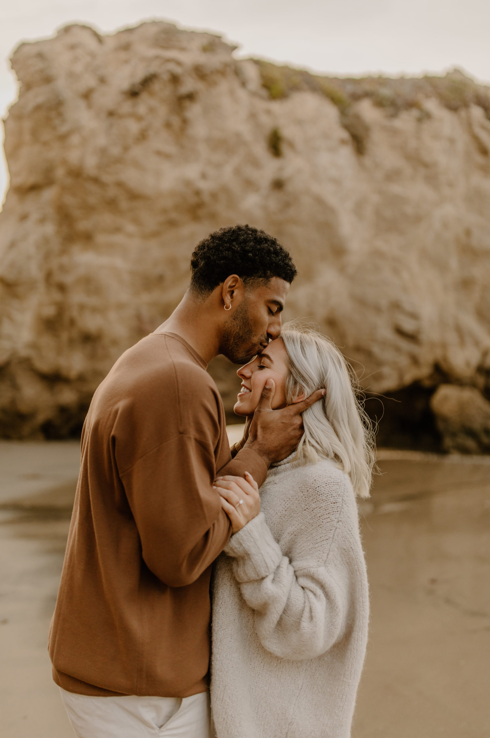 candid unique engagement photos at the beach in Malibu California forehead kiss