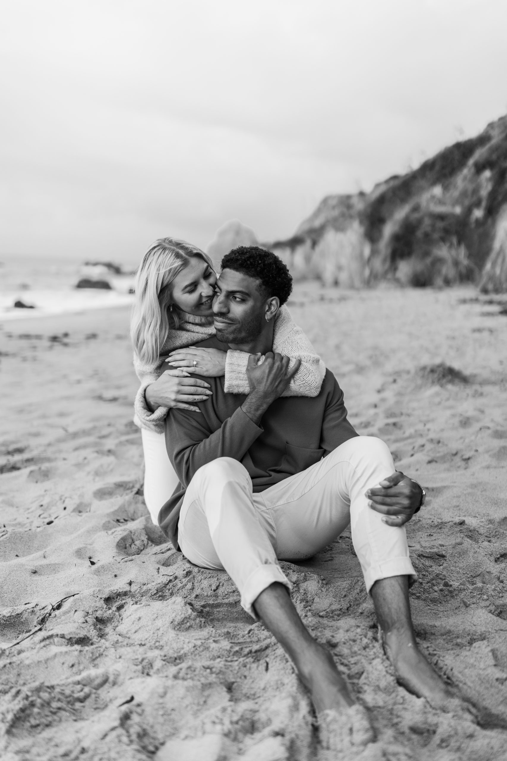 couple hugging on the beach engagement photo poses