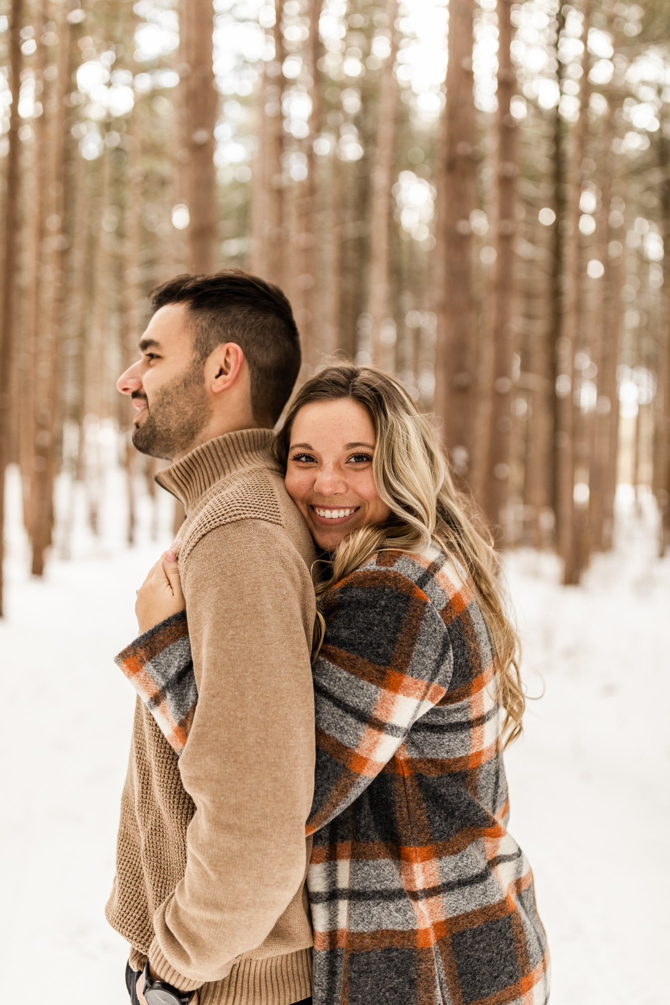candid snow winter engagement photos in Michigan forest 