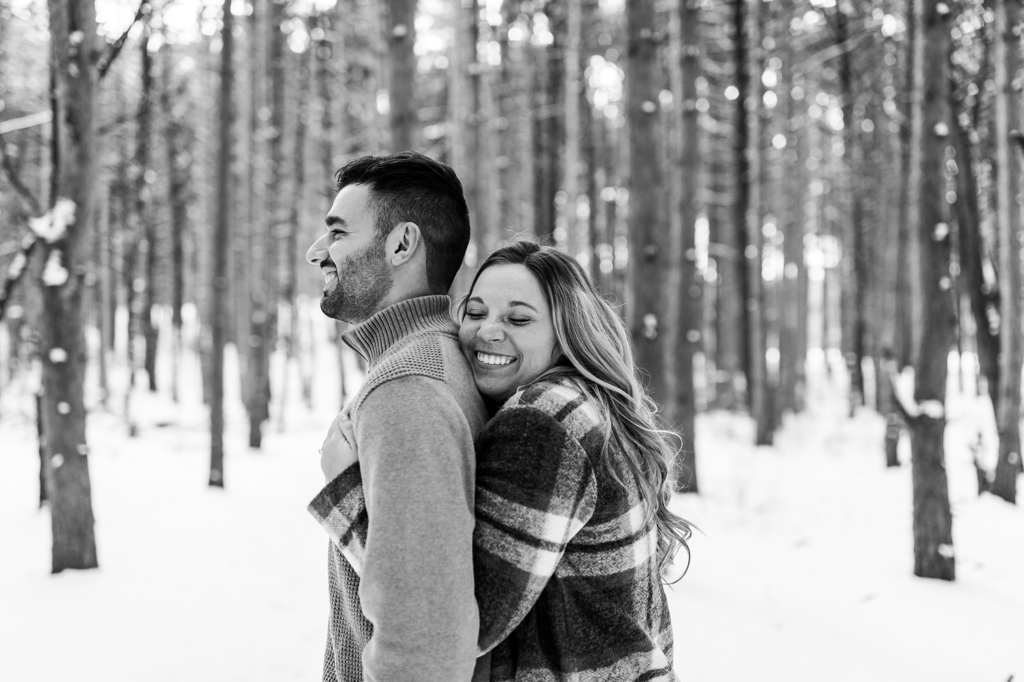 candid snow winter engagement photos in Michigan forest black and white