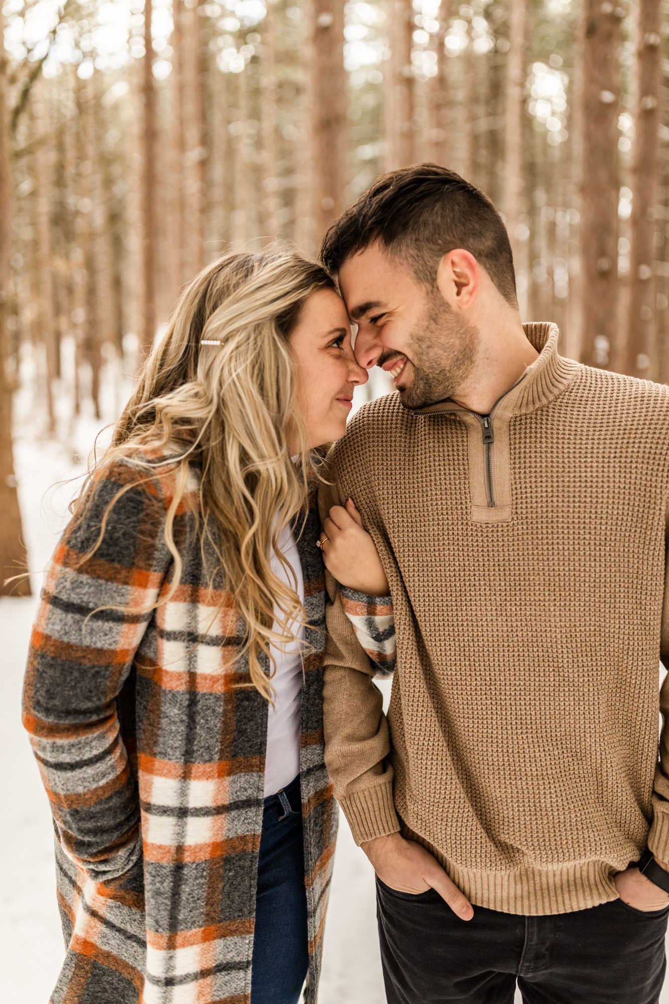 candid couple photos in winter engagement shoot in Michigan forest 