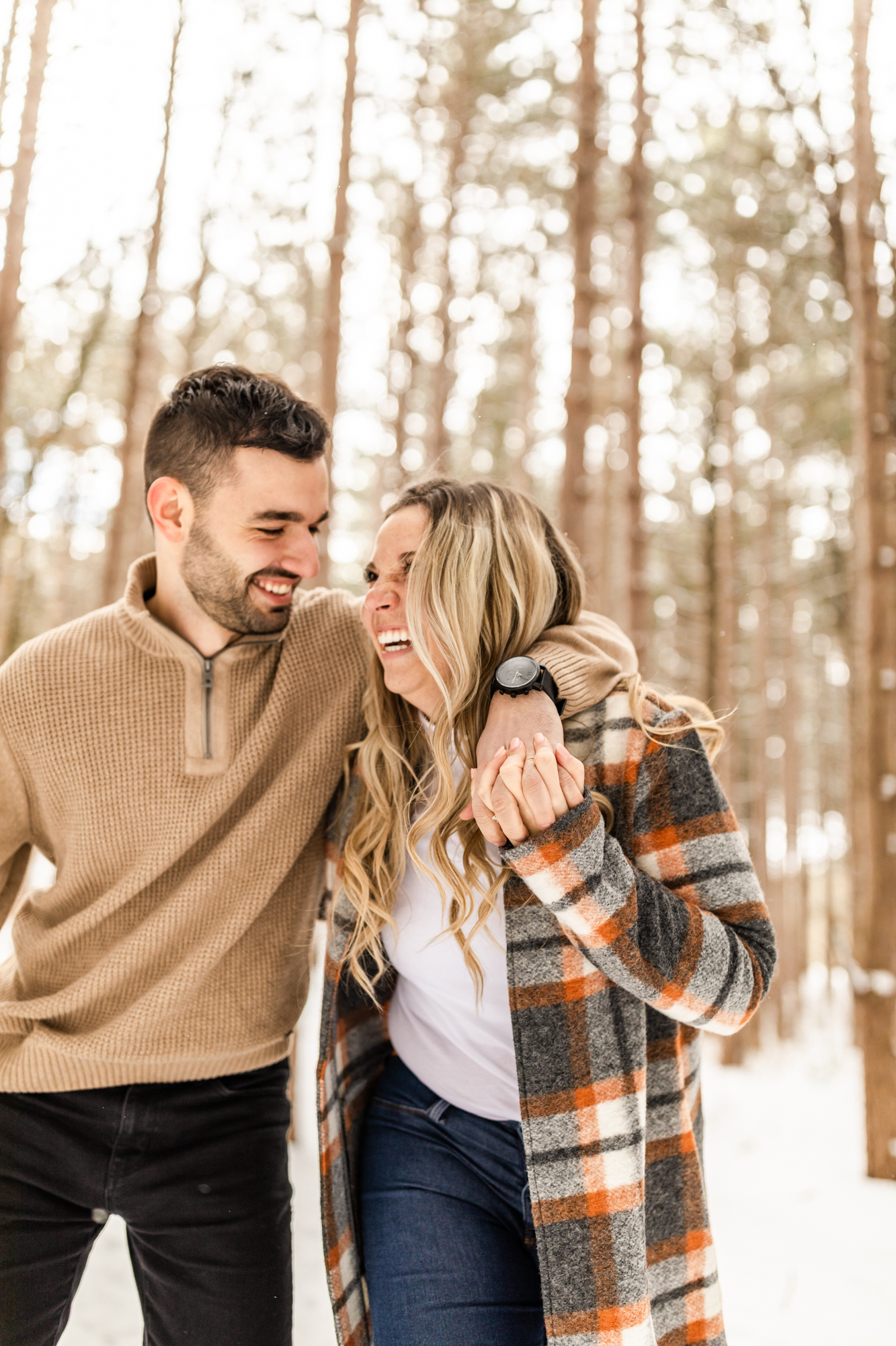 candid snowy winter engagement photos in Michigan forest 