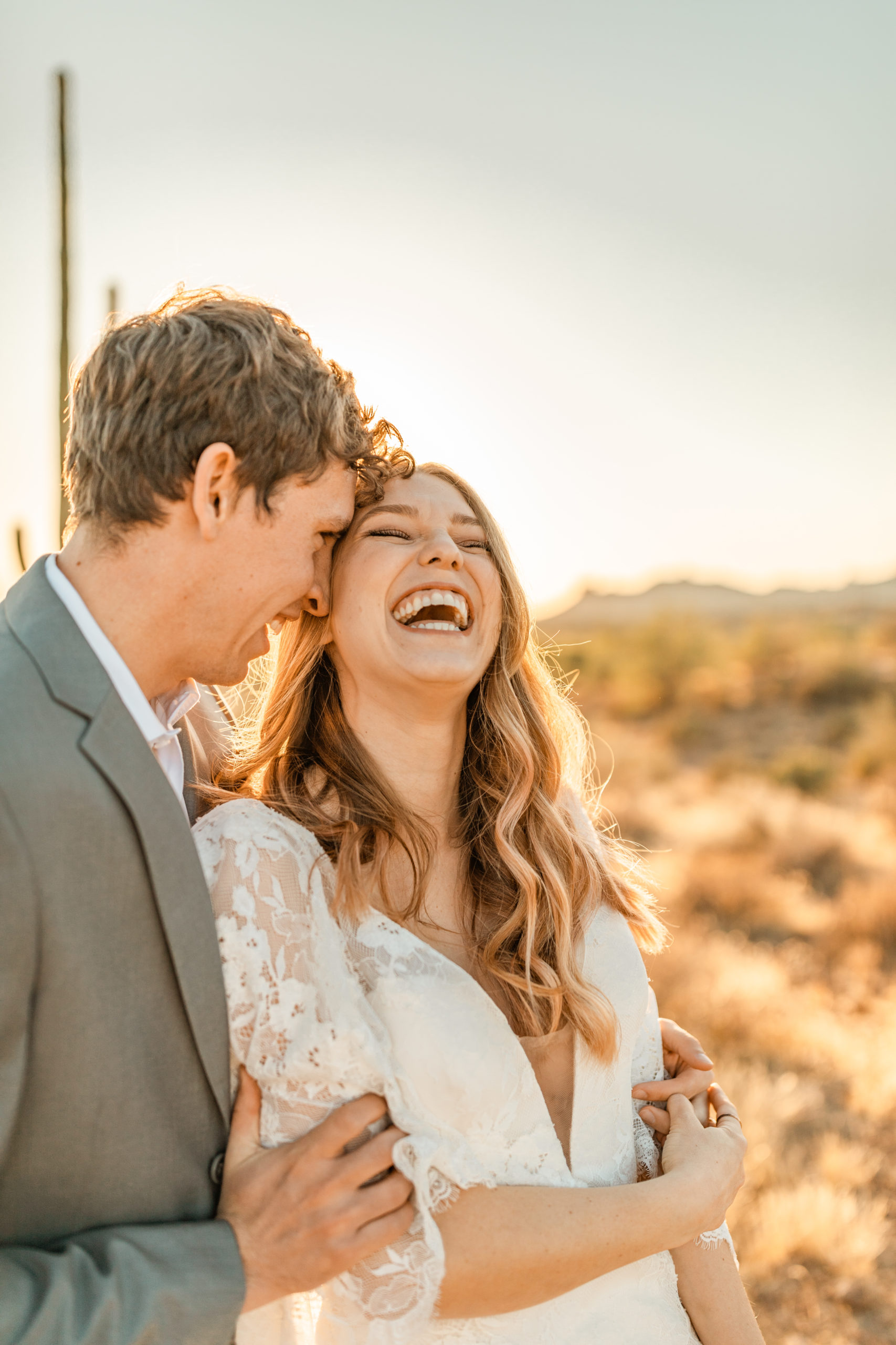 bride and groom laughing at Arizona desert elopement candid wedding photos