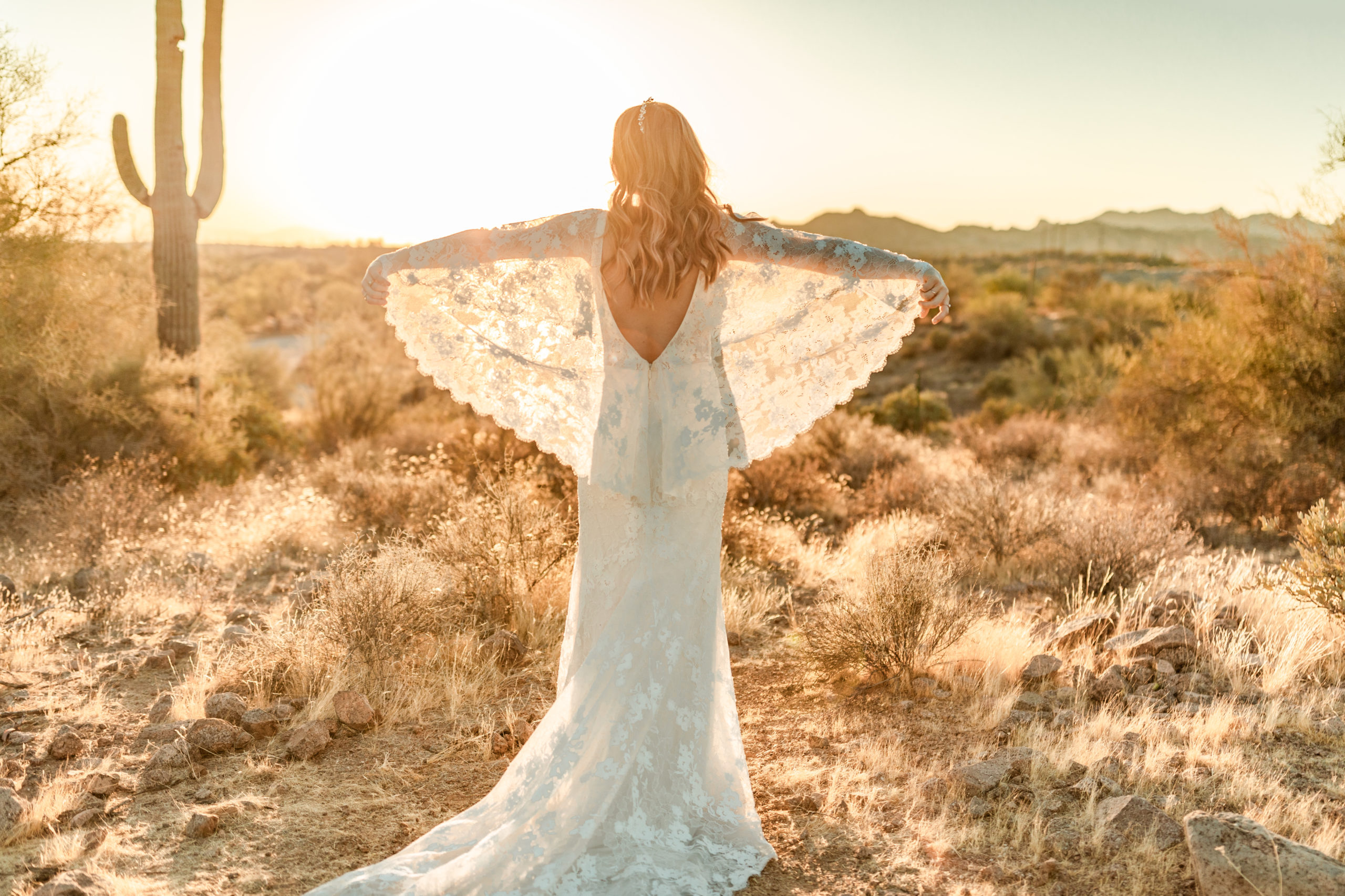 bride posing with arms outstretched in Arizona desert elopement