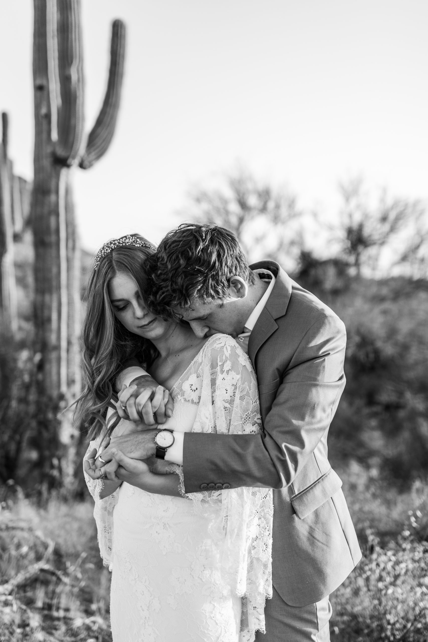 bride and groom hugging in front of cactus Arizona elopement