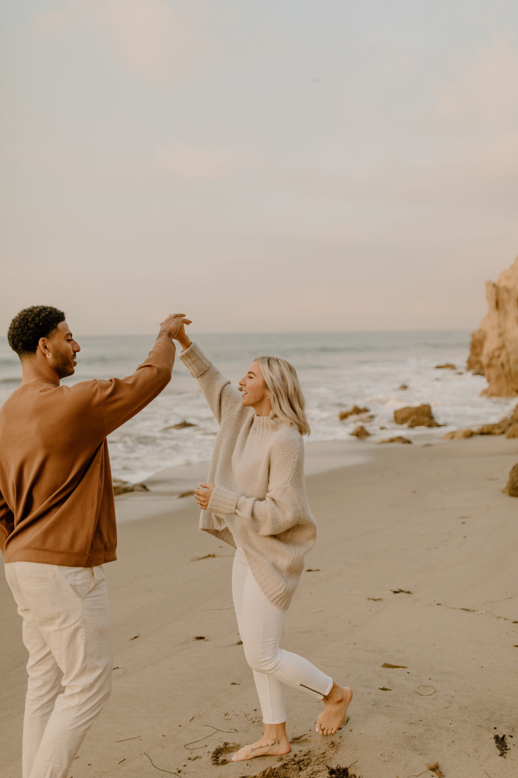 couple dancing on beach in California for sunrise engagement photos