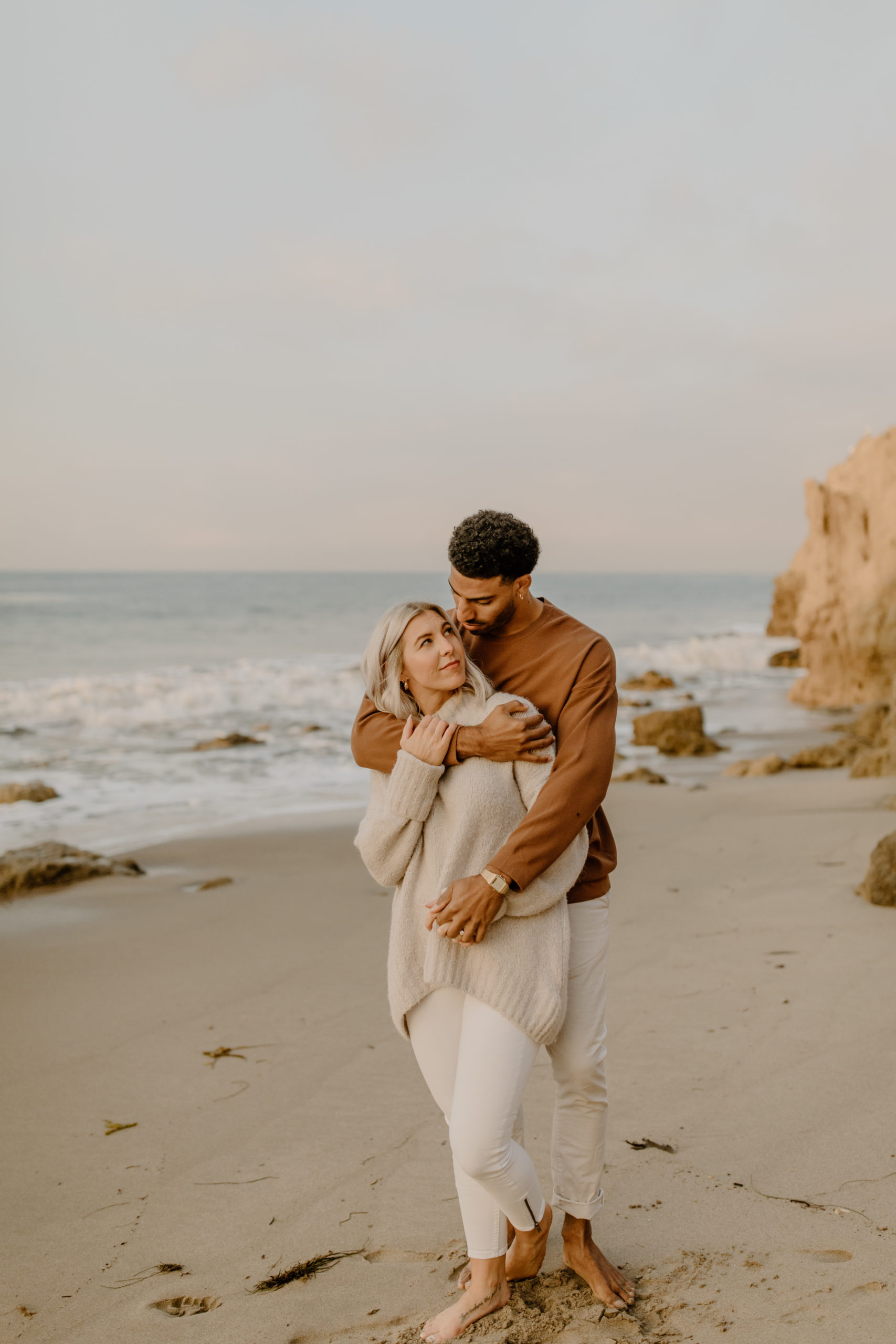 couple hugging on beach in California Malibu engagement photo session