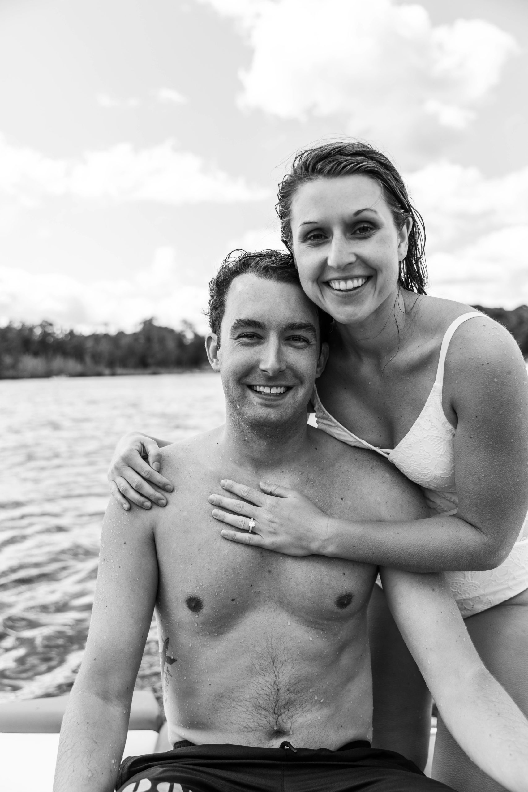 surfing engagement photos in Michigan, couple on boat in swimsuits
