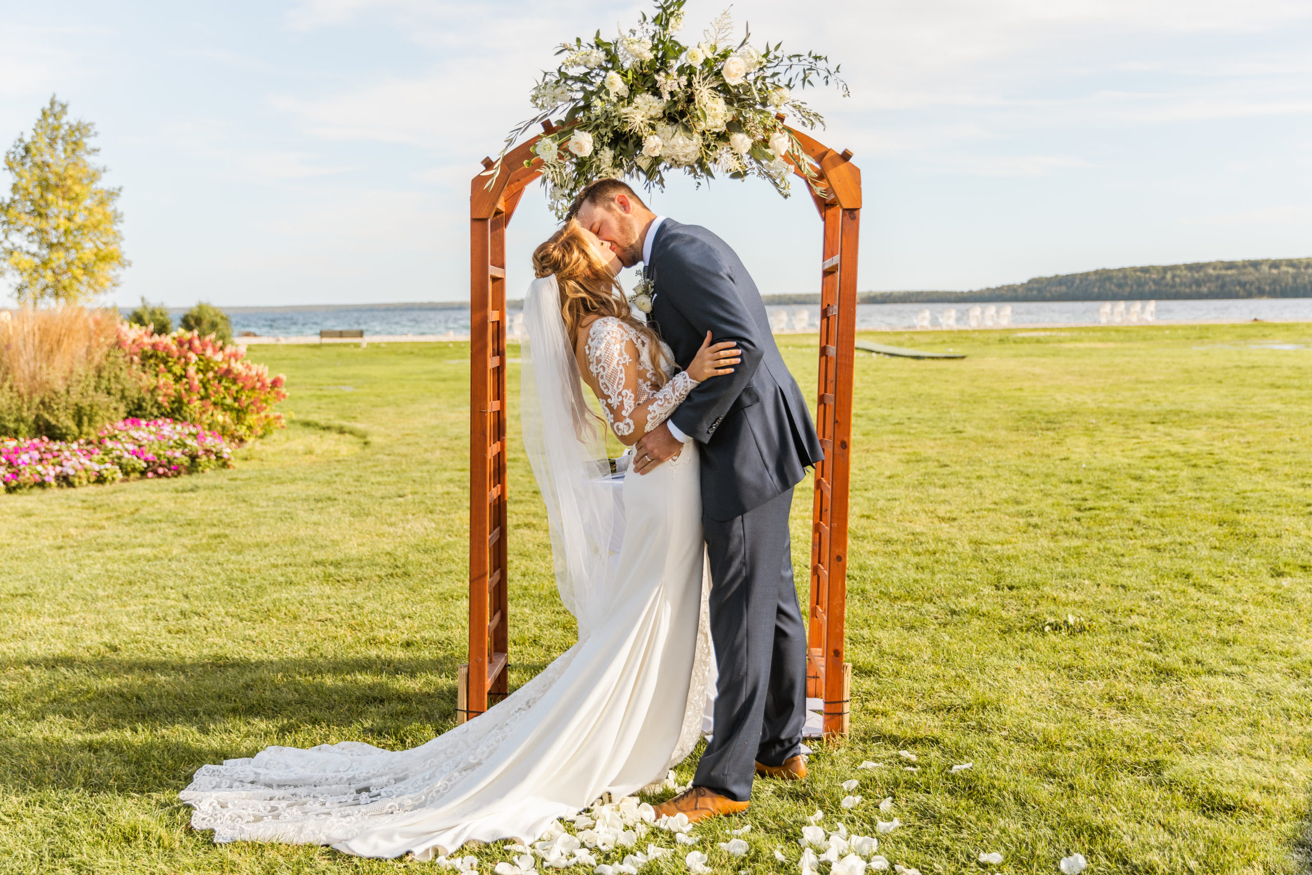 Bride and Groom Kissing at Mackinac Island wedding ceremony on lawn in front of Lake Michigan