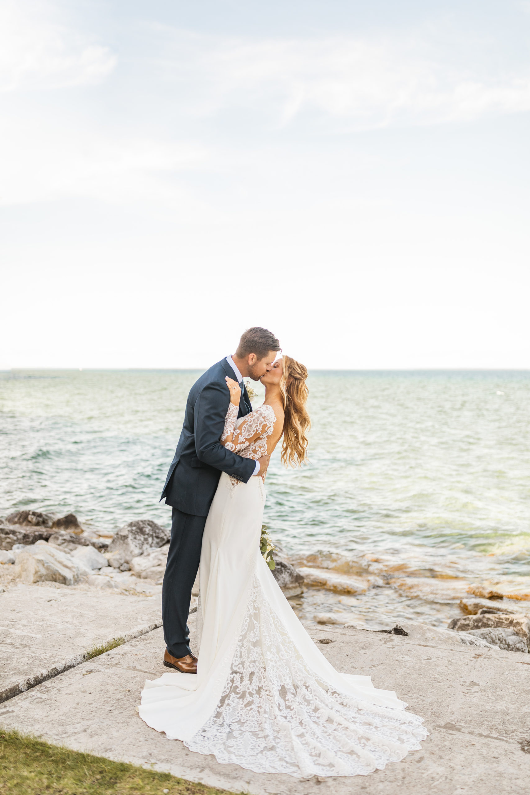 Bride and groom kissing in front of Lake Michigan