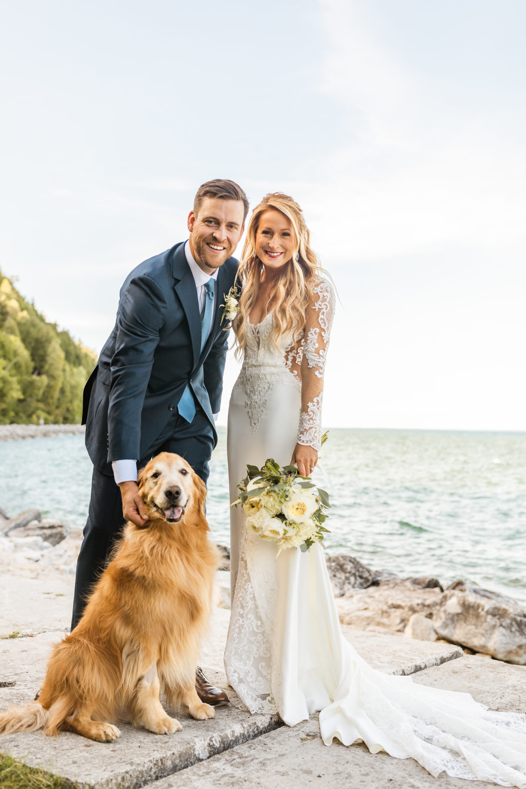 Bride and groom posing with dog at Lake Michigan Mackinac Island wedding
