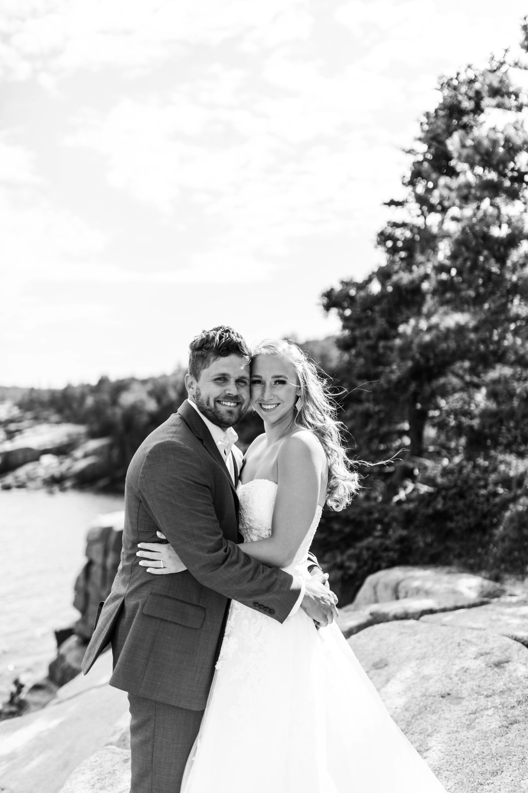 bride and groom hugging  overlooking ocean at Acadia National Park