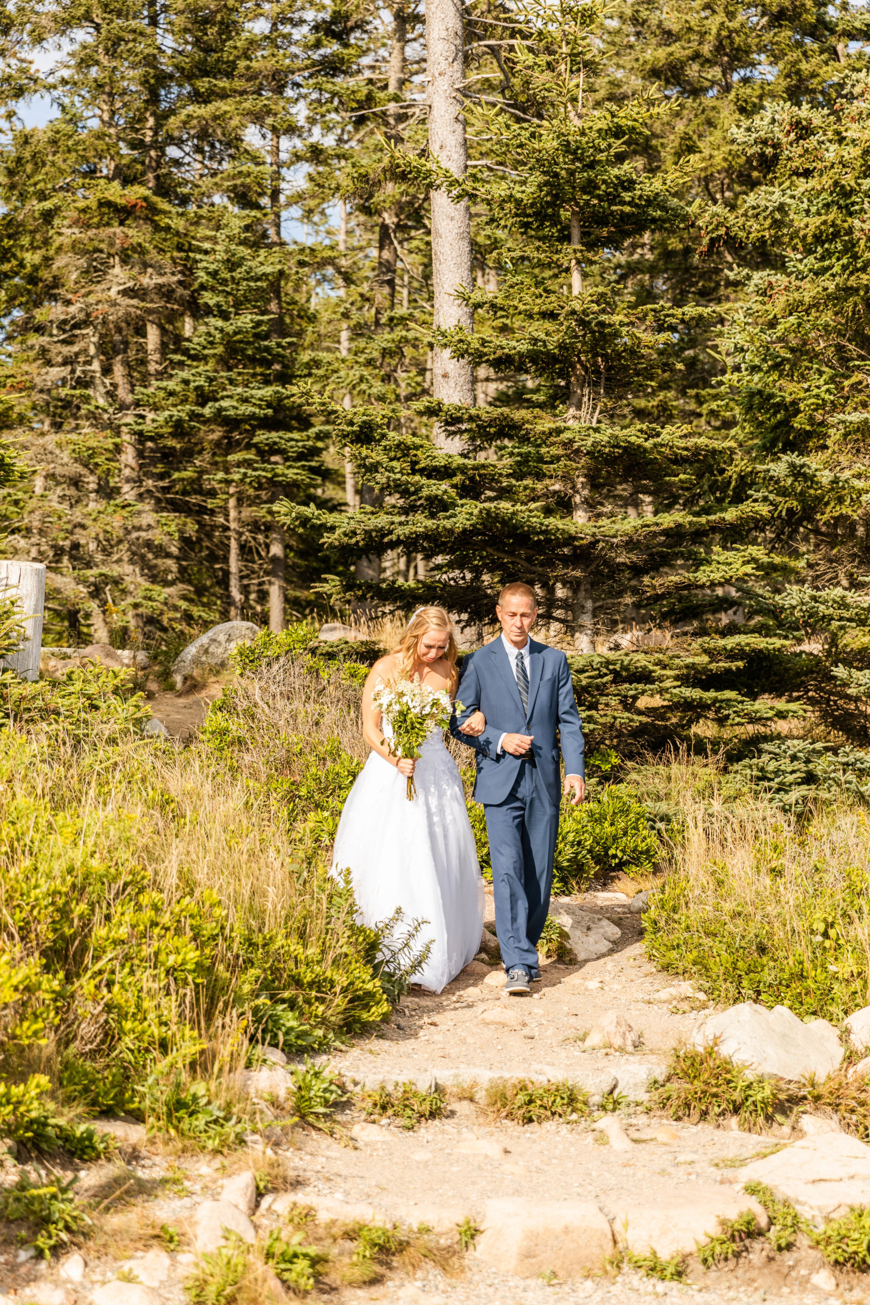 bride and father walking down wooded aisle in national park elopement