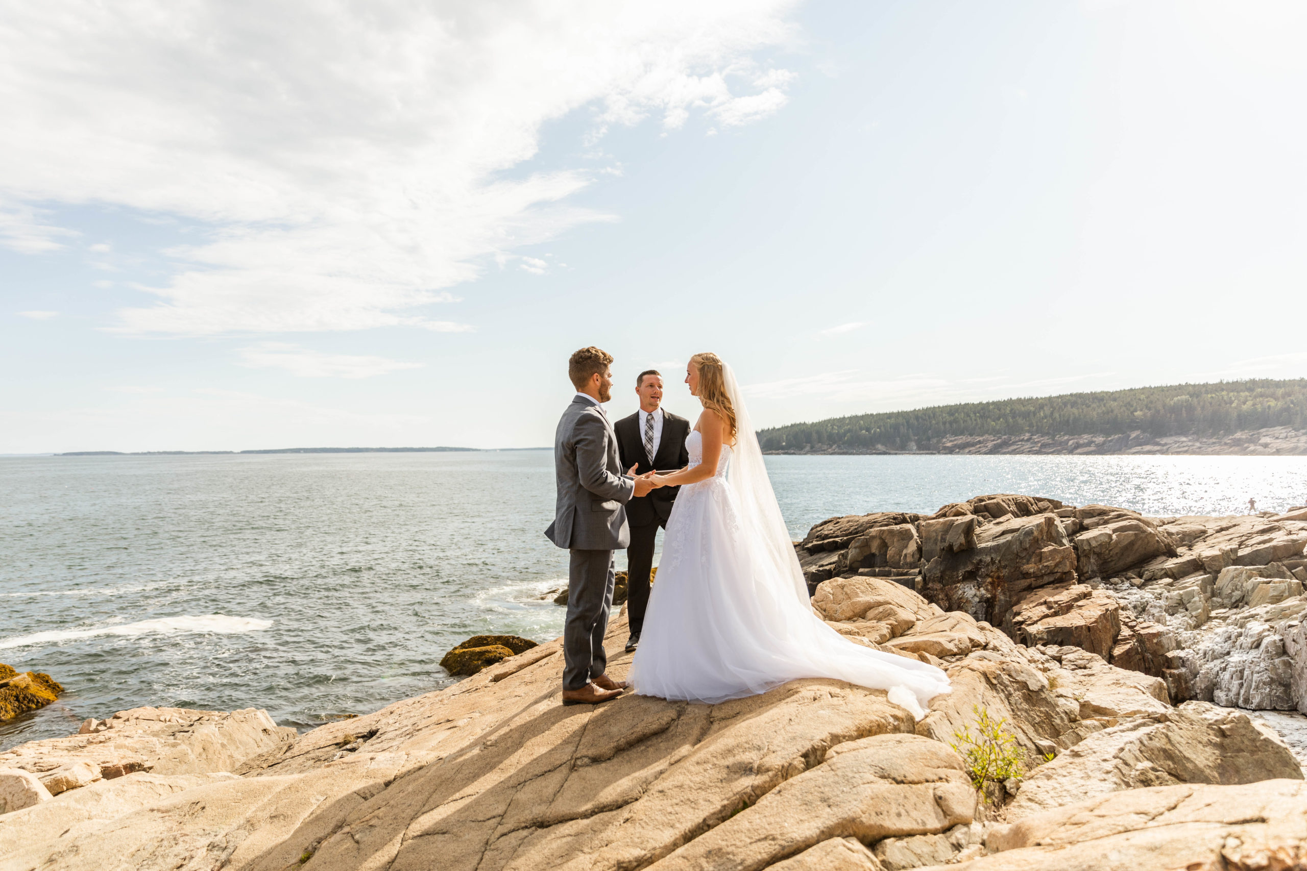 bride and groom standing in front of officiant at acadia national park elopement