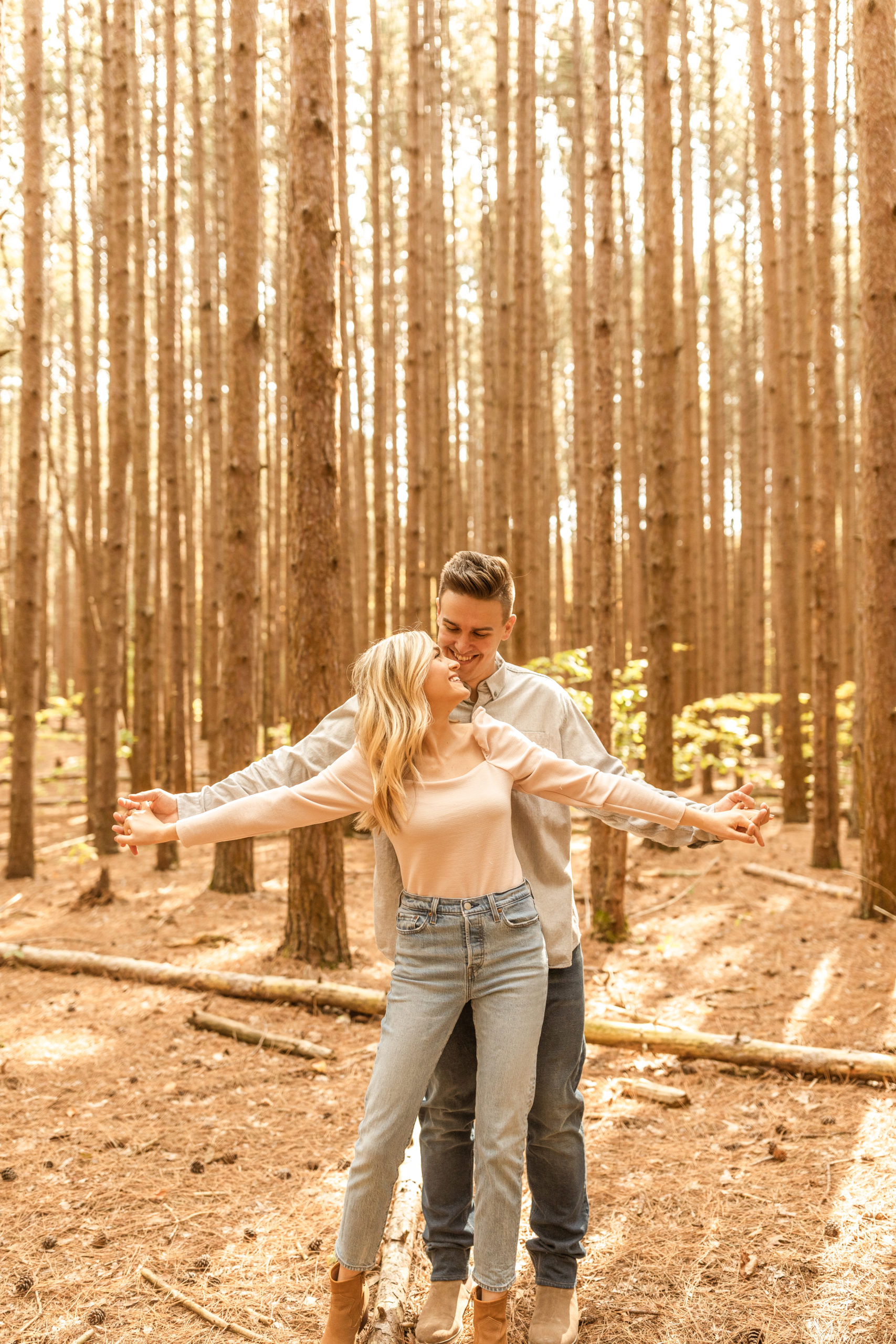 couple holding hands in a wooded forest candid engagement photos