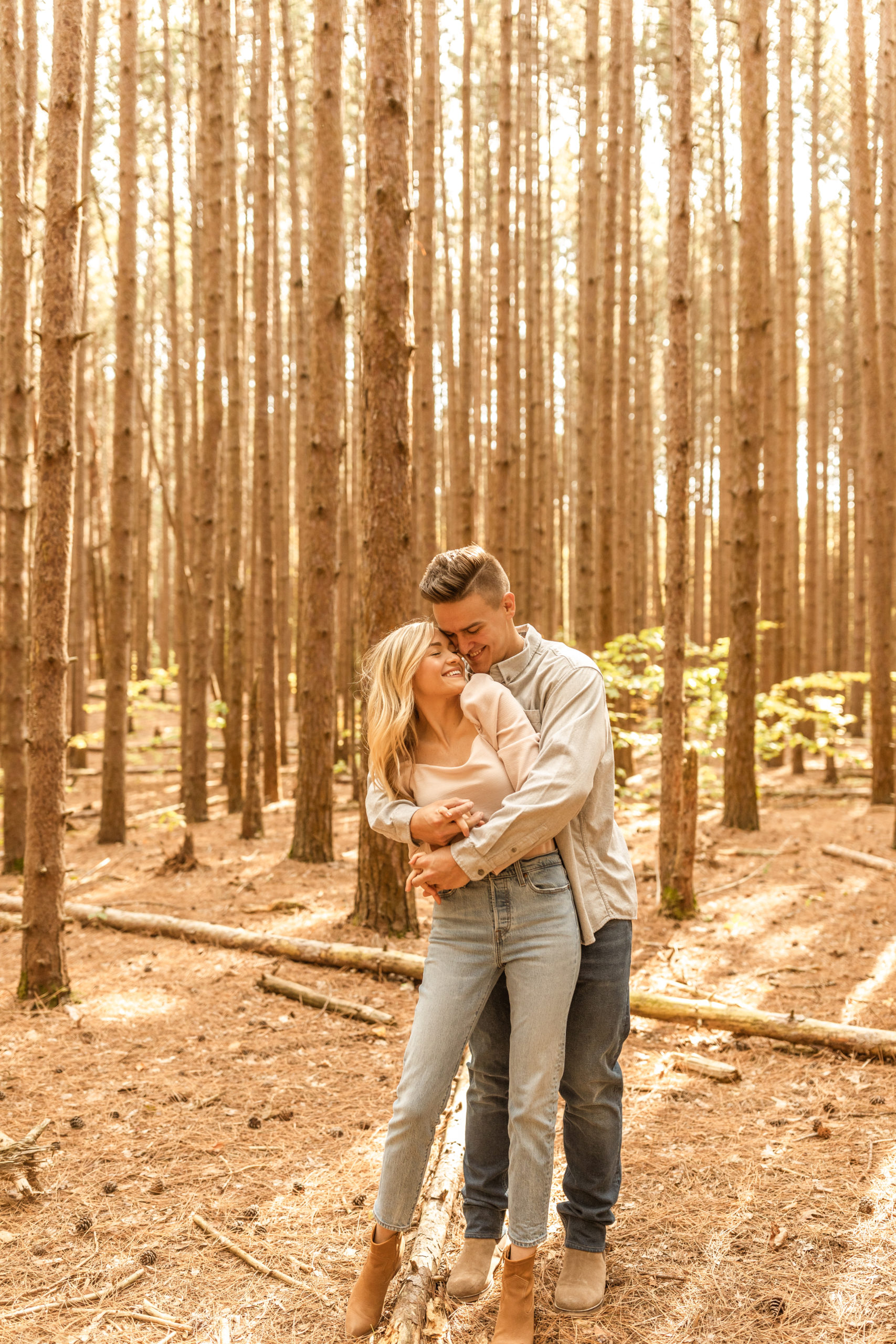 couple hugging in a wooded forest candid engagement photos