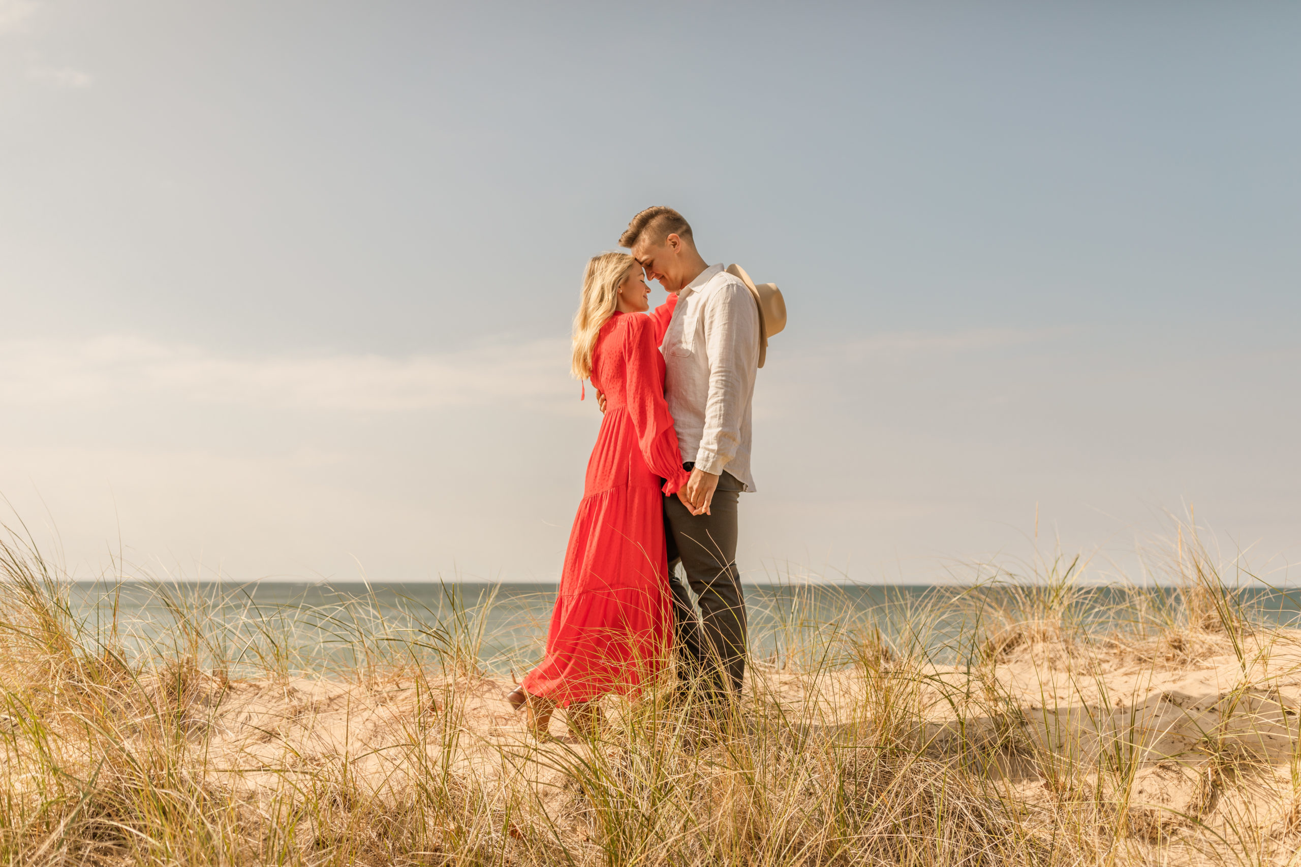 couple hugging on the beach in candid engagement photos