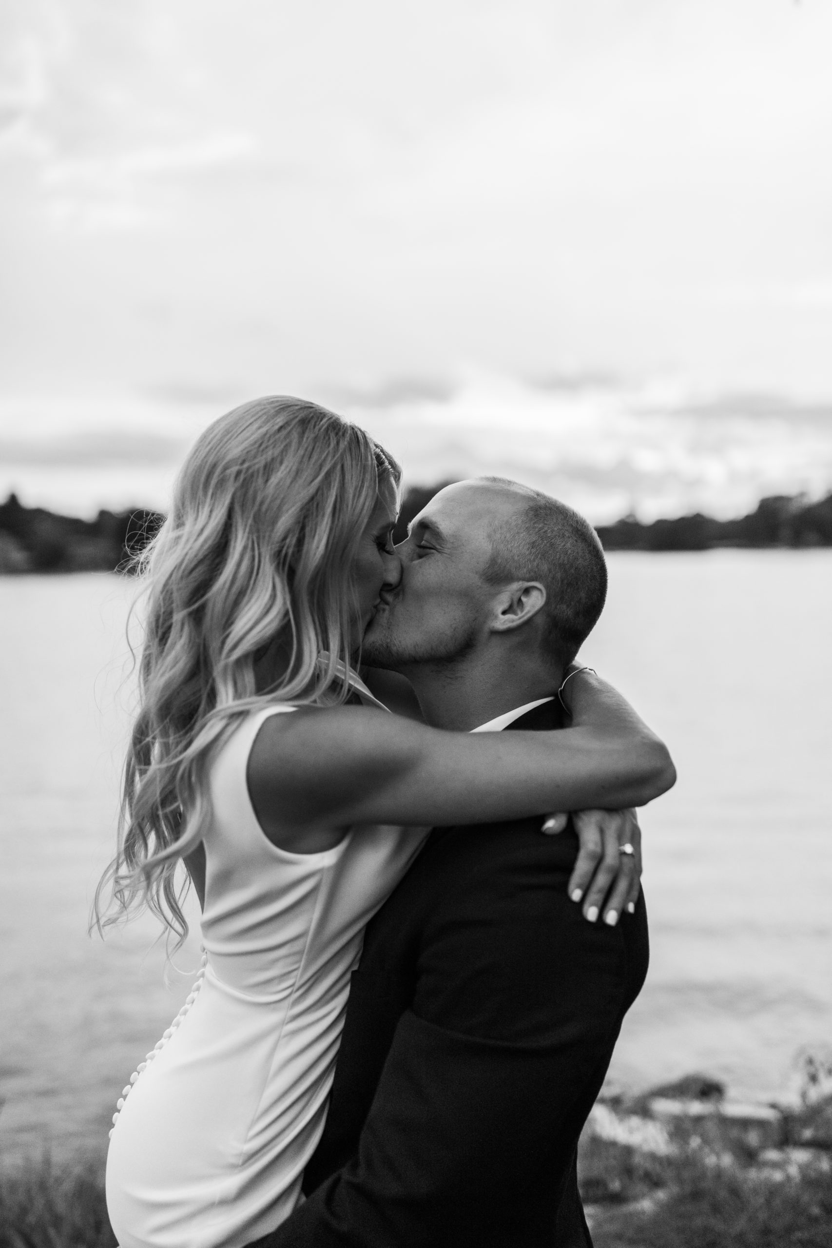 bride and groom kissing in front of lake Michigan wedding photos