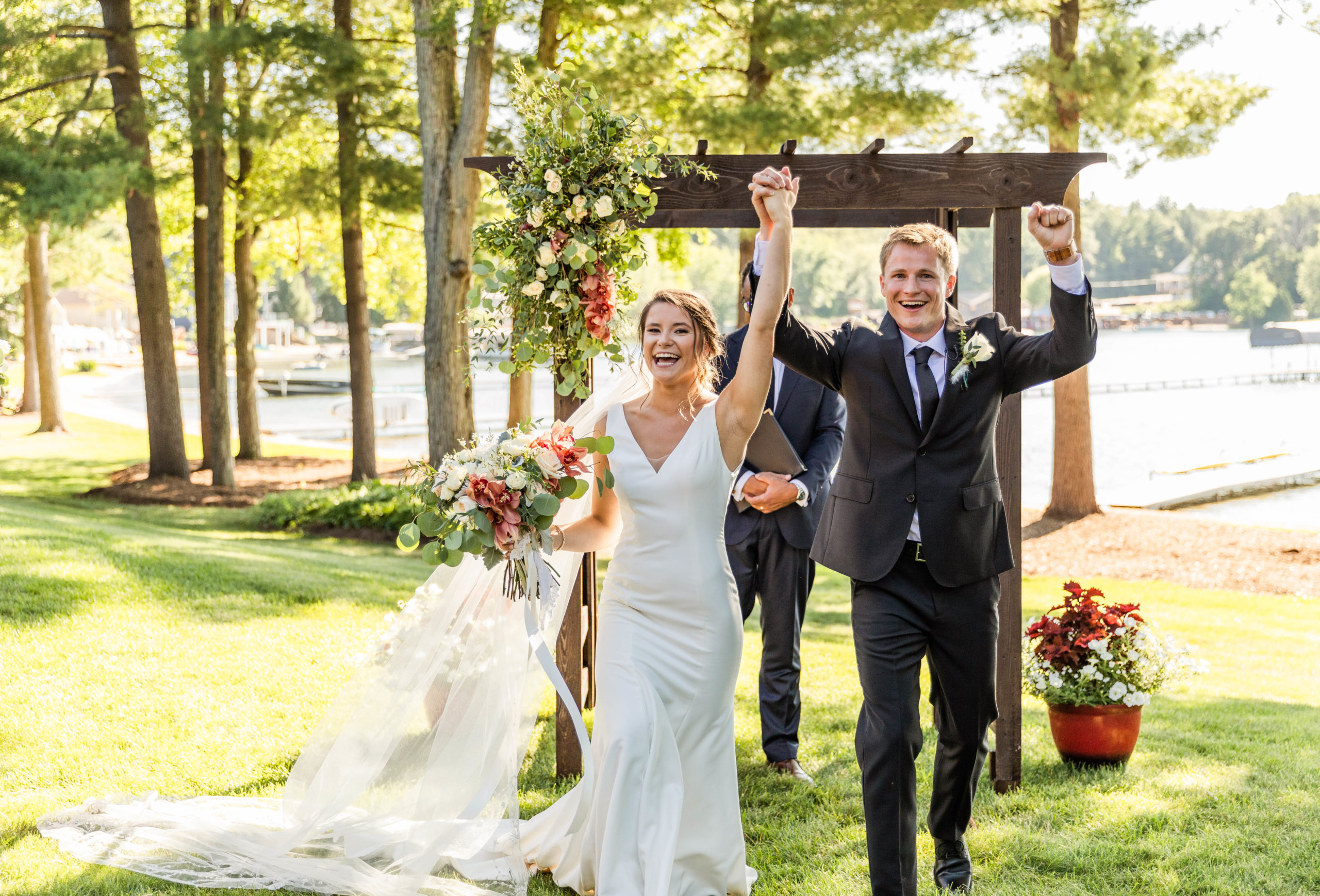 bride and groom cheering at lakefront wedding ceremony in Michigan