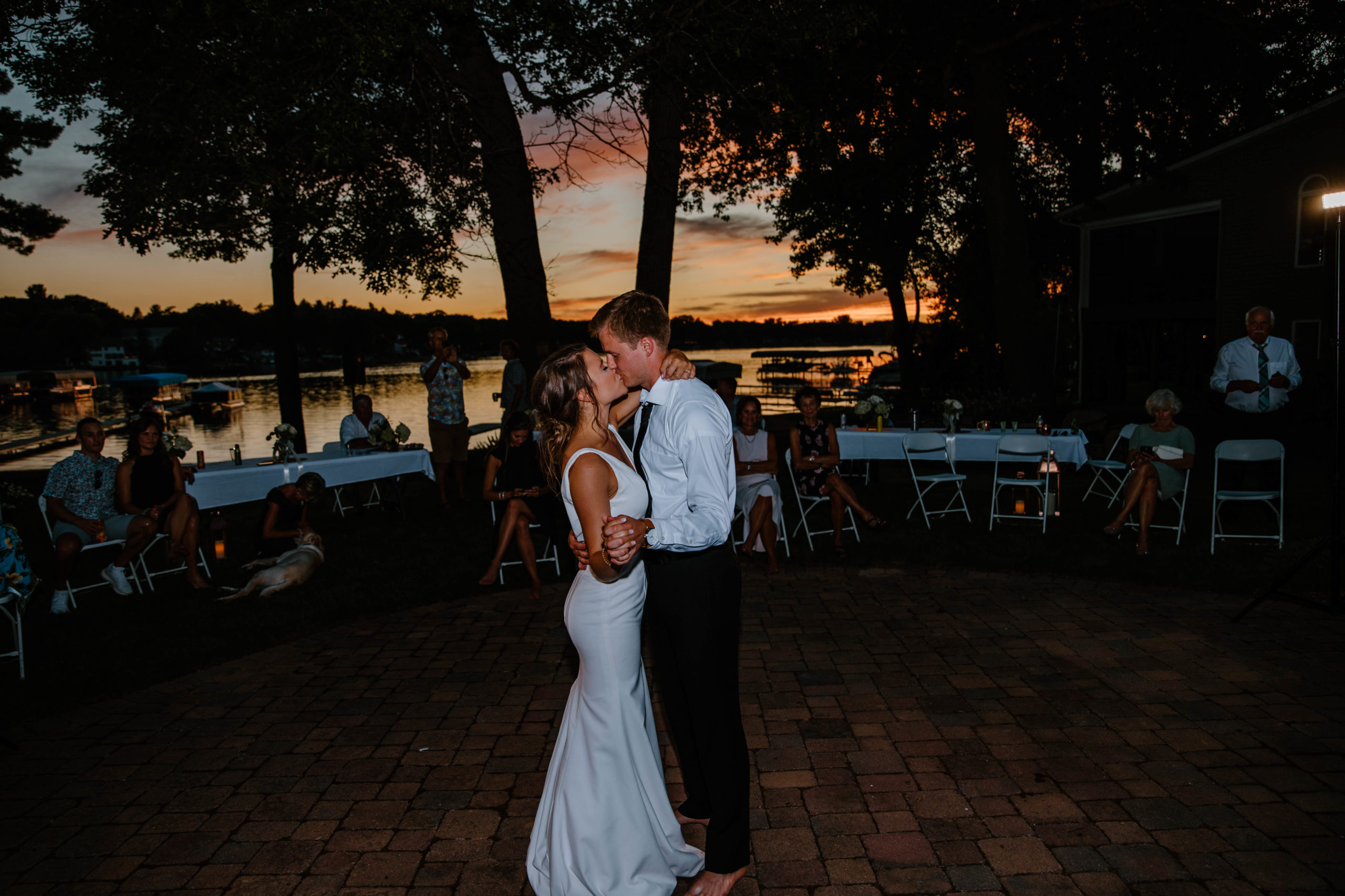 bride and groom dancing at lakefront wedding reception at sunset
