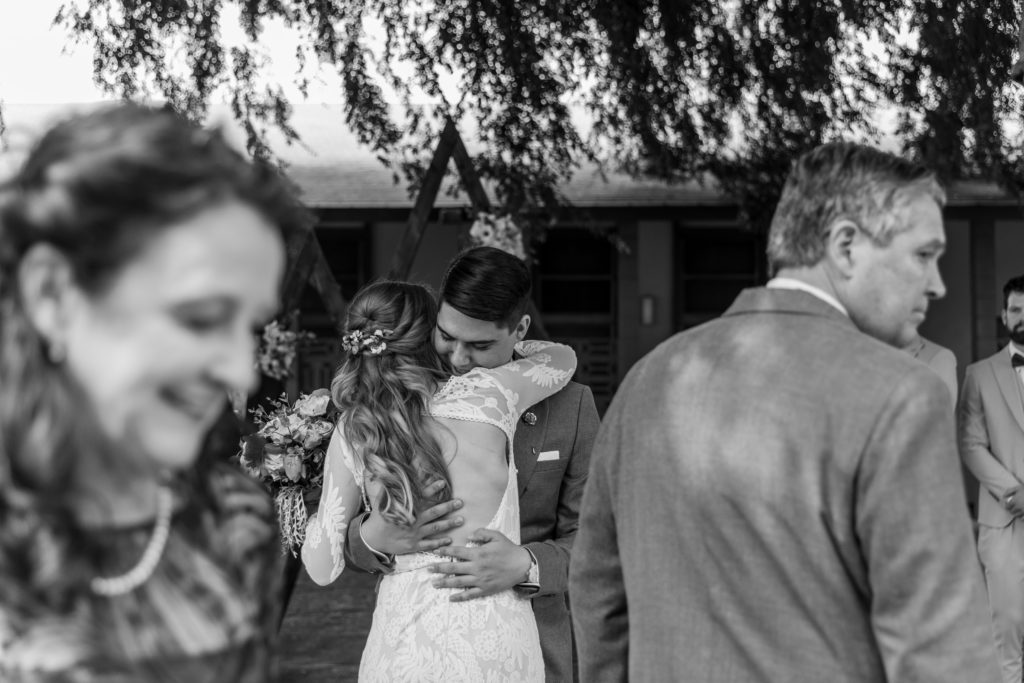 Candid Intimate Wedding Photographer black and white of bride and groom hugging 