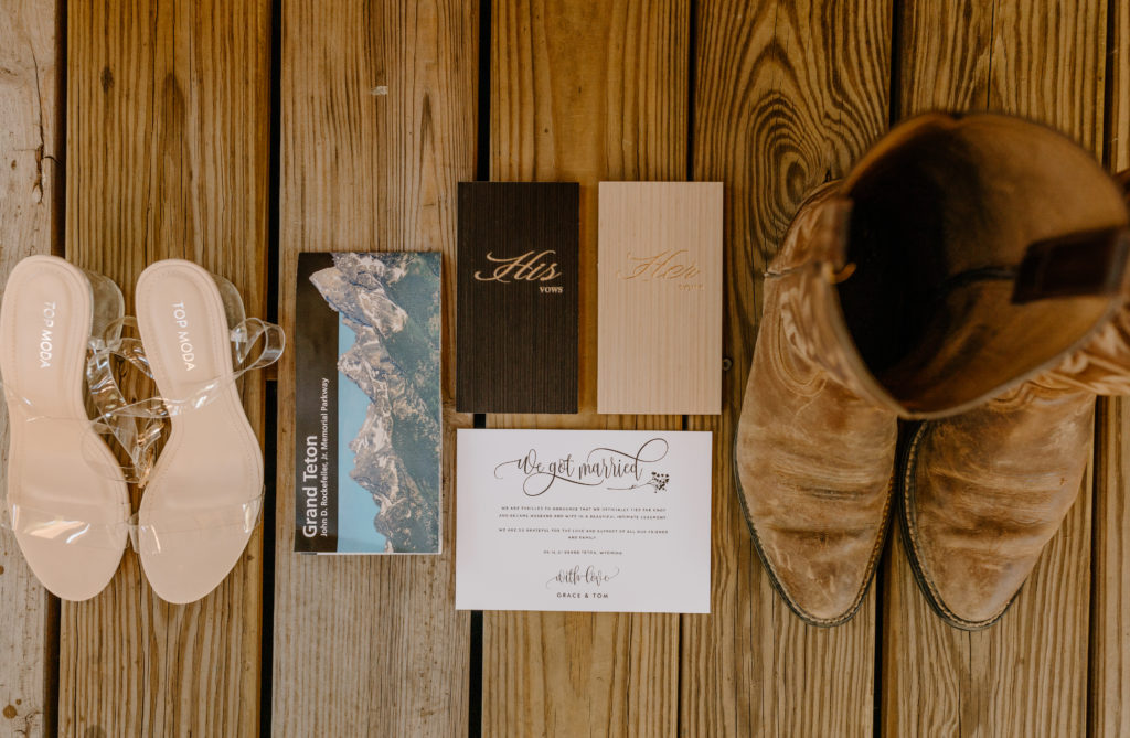 Flatlay elopement wedding detail photos invite cowboy boots clear heel bridal shoes