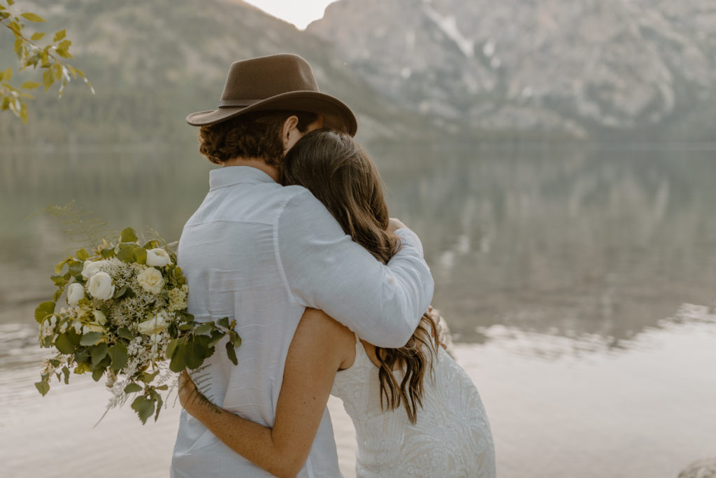 Candid Elopement Photos Bride and Groom Hugging by Mountains