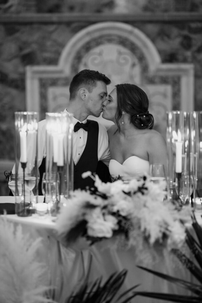 Destination wedding in Italy bride and groom kissing at sweetheart table